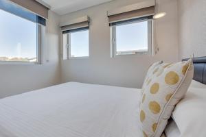 a bedroom with a bed and two windows at Professional living minutes from the city in Sydney