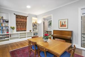 a dining room with a table and a piano at Family Terrace Home Close to Oxford Street and CBD in Sydney