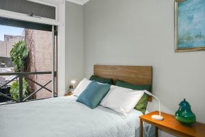 a bedroom with a bed with a large window at Family Terrace Home Close to Oxford Street and CBD in Sydney