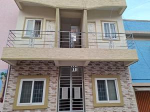 una casa con un balcón encima en Home suite, en Bangalore