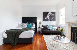 a bedroom with a bed and a couch at Cosy nook in inner-city Victorian mansion in Sydney