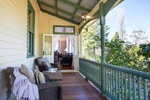 - une terrasse couverte avec 2 chaises et une table dans l'établissement Spacious Heritage Home with Sauna in Leura, à Leura