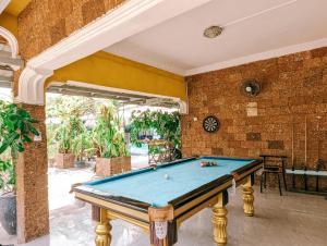uma mesa de bilhar num quarto com uma parede de tijolos em Yellow Star Hostel em Kampot