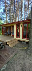 ein kleines Haus mit einer Terrasse und einem Baum in der Unterkunft Reinholdi puhkemaja in Jabara