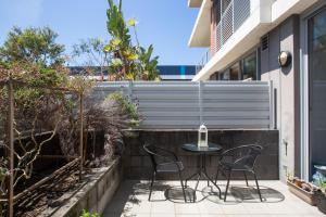 een kleine patio met een tafel en 2 stoelen bij Spacious Modern Apartment In Sydney's North Shore in Sydney