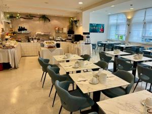 una sala da pranzo con tavoli e sedie e una caffetteria di Hotel Castiglione a Lignano Sabbiadoro
