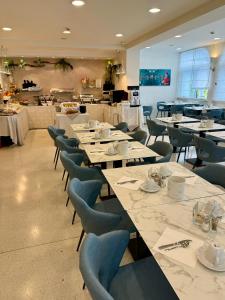 une salle à manger avec des tables et des chaises ainsi qu'une cafétéria dans l'établissement Hotel Castiglione, à Lignano Sabbiadoro