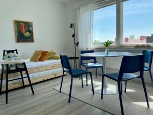 a living room with a table and chairs and a couch at Studio korttelin päässä Olavinlinnasta in Savonlinna