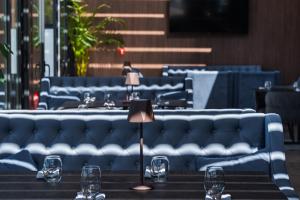 Medite Spa Resort and Villas في ساندانسكي: طاولة مع كؤوس للنبيذ وأريكة زرقاء