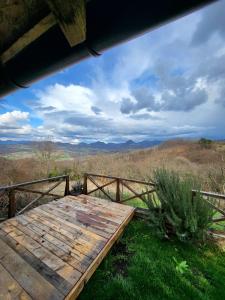 una terraza de madera con vistas a las montañas en Apartmani Lunija, en Gornji Milanovac