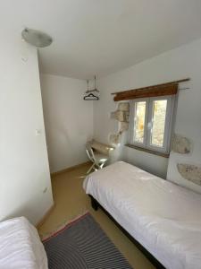 a bedroom with two beds and a window at Heat Hostel in Susak