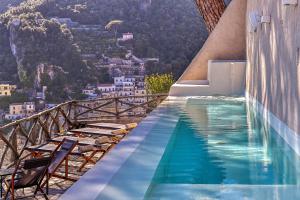 una piscina con sedie e una montagna di Casa Massa Amalfi ad Amalfi