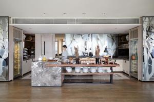 a kitchen with a counter with a person in the background at Four Seasons Hotel Seoul in Seoul