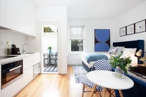 a living room with a bed and a table at Bright and Beautiful Studio in Quiet Neighbourhood in Sydney