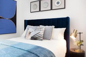 a bedroom with a blue and white bed with pillows at Bright and Beautiful Studio in Quiet Neighbourhood in Sydney