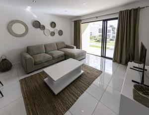 a living room with a couch and a table at Modern Oceanview Apartment D1 in Flic-en-Flac