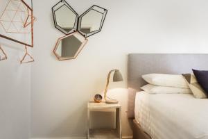 een slaapkamer met een bed en twee spiegels aan de muur bij Suburban Two-bed Apartment with Parking and Patio in Sydney