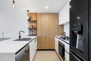 una cocina con encimeras blancas y armarios de madera en Convenient 2-Bed Apartment with Panoramic Views, en Brisbane