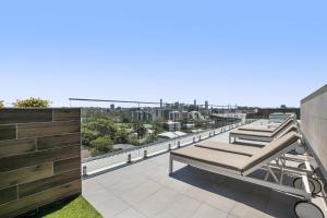 Convenient 2-Bed Apartment with Panoramic Views في بريزبين: شرفة بسريرين فوق مبنى