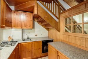 kuchnia z drewnianymi szafkami i schodami w obiekcie Villa Lacedel - Stayincortina w mieście Cortina dʼAmpezzo