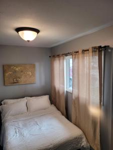 1 dormitorio con cama y ventana en Compact But Cozy Too en Anchorage
