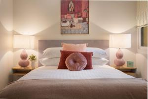 Cosy 2-Bed Apartment in the Heart of Strathfield في سيدني: غرفة نوم بسرير كبير فيها مصباحين