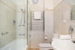 Cosy 2-Bed Apartment in the Heart of Strathfield في سيدني: حمام مع دش ومرحاض ومغسلة