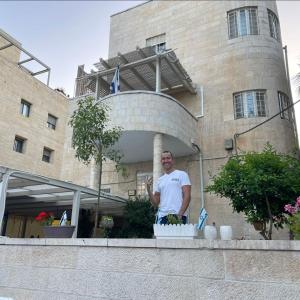 Ein Mann steht vor einem Gebäude. in der Unterkunft Mike's House Jerusalem in Jerusalem
