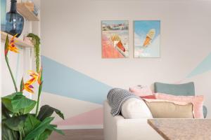 a living room with a white couch and a plant at Cosy 2-Bed Apartment in the Heart of Strathfield in Sydney +7 photos