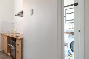 a white kitchen with a washer and dryer in it at Central 2-Bed Apartment with Private Parking in Sydney