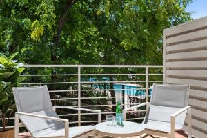 - 2 chaises blanches et une table sur la terrasse dans l'établissement Classy Beachside Unit with Parking and Gym, à Melbourne