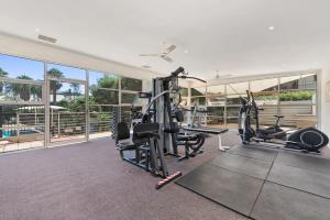 einen Fitnessraum mit zwei Laufbändern und Crosstrainern in der Unterkunft Classy Beachside Unit with Parking and Gym in Melbourne