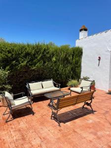 a group of chairs and a bench on a patio at Casa Rural Cortijo Cerro Limon in Málaga