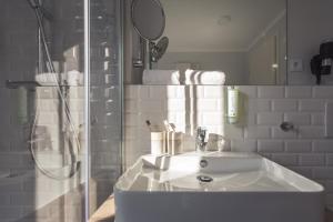 een witte badkamer met een wastafel en een douche bij Yggotel Mejse in Wenen