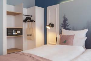 1 dormitorio con 1 cama blanca y TV en Yggotel Mejse, en Viena