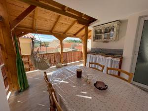 a dining room with a table and a kitchen at Heat Hostel in Susak