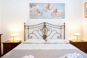 um quarto com uma cama branca com duas mesas de cabeceira em La Lamia em Cisternino