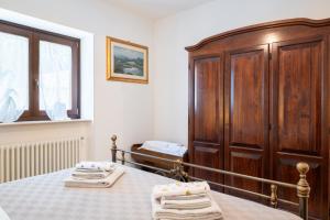 Un dormitorio con una cama y un armario de madera. en La Lamia, en Cisternino