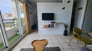 sala de estar con TV y silla en Studio Océan City, en Saint-Pierre
