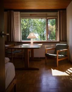 une chambre avec une table, une chaise et une fenêtre dans l'établissement Løgumkloster Refugium, à Løgumkloster