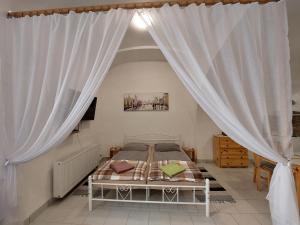 a bedroom with a bed with white curtains at apartmány LEVOČA in Levoča