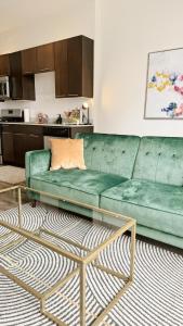a living room with a green couch and a coffee table at Luxury Hollywood Apartment in Los Angeles