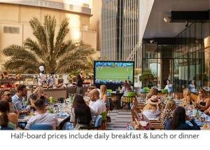 un gruppo di persone seduti ai tavoli in un ristorante di Crowne Plaza Dubai Marina, an IHG Hotel a Dubai
