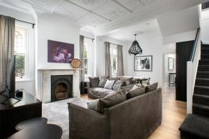 a living room with a couch and a fireplace at Elegant 3-Bed Heritage House with Swimming Pool in Sydney