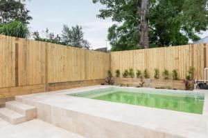 a swimming pool in a backyard with a wooden fence at Elegant 3-Bed Heritage House with Swimming Pool in Sydney