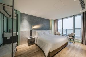 石門區的住宿－半島海悅渡假會館，一间卧室设有一张大床和一个大窗户