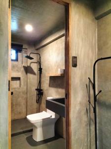 uma casa de banho com um WC, um chuveiro e um lavatório. em Patar Palms em Bolinao