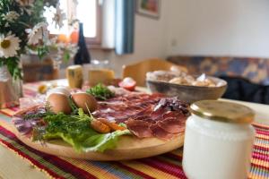 uma pizza com carne e vegetais numa mesa em Patztauhof Wohnung Tschavalatsch em Sluderno