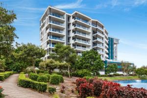 an apartment building with a garden and a swimming pool at Lakeside Family Oasis with Pool, Gym and Balcony in Gold Coast