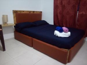 a bed with a blue blanket and a stuffed animal on it at 2SB Hospedagem in Praia